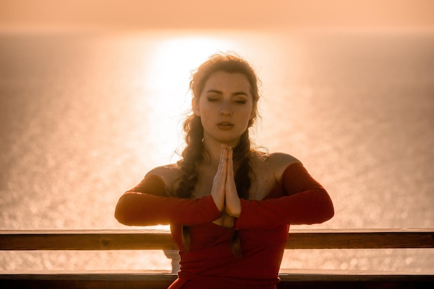 Foto ritratto del primo piano della giovane donna castana sensuale in vestito rosso che balla felicemente all'aperto isolato sopra