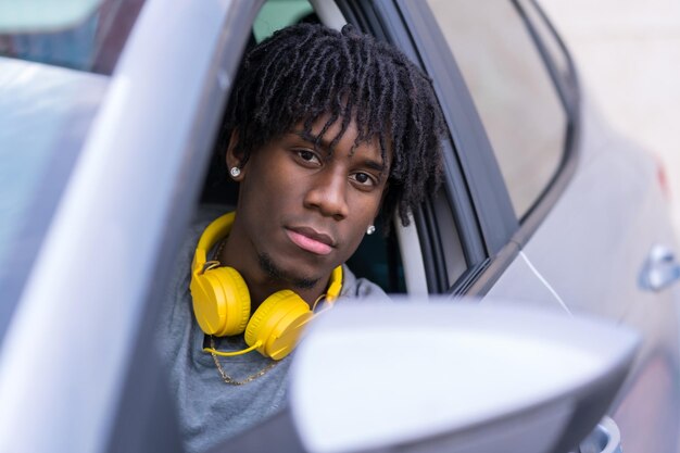 Closeup portrait of a serious african young man inside a car