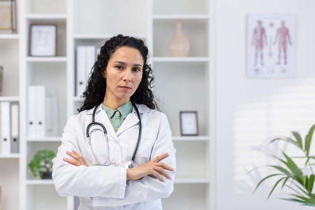 Closeup portrait of serious and confident hispanic female doctor woman looking at camera with