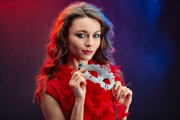 Closeup portrait of a sexy girl holding mask in her hands