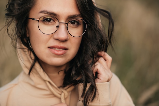 closeup portrait of smiling brunette girl in glasses and hood