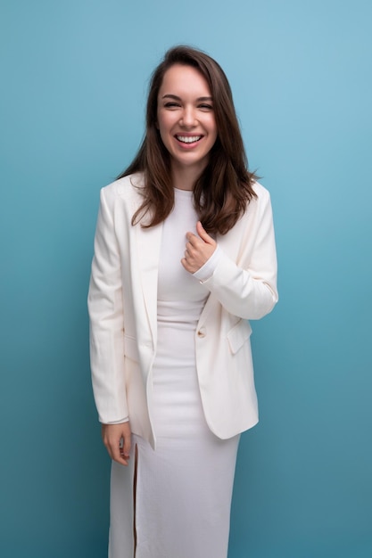 Closeup portrait of a smiling european brunette woman with long hair in a white dress and jacket