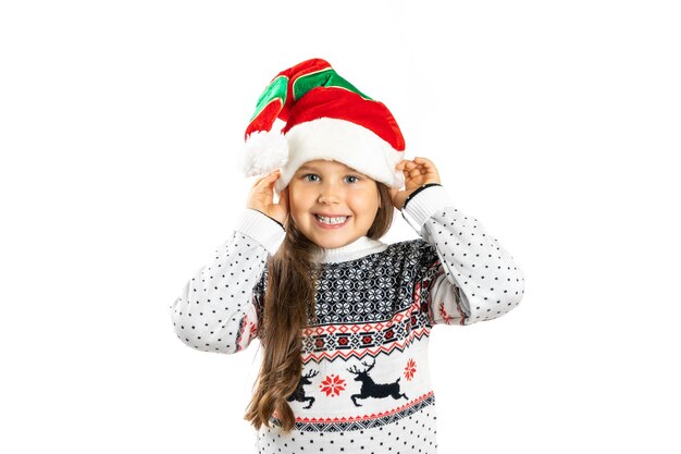 Closeup portrait of smiling positive girl in white knitted christmas sweater with reindeer holding g...