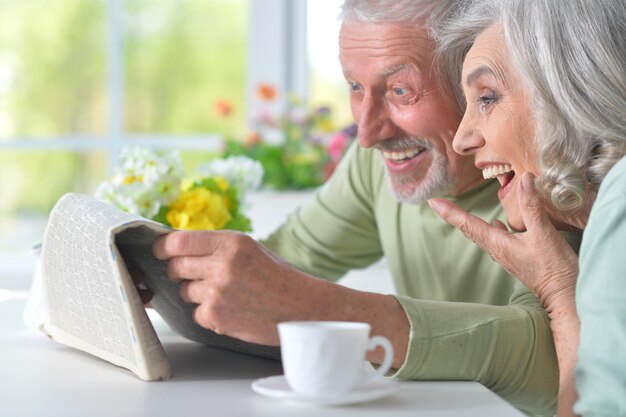 Closeup portrait of a smiling senior couple with newspaper