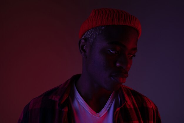 Closeup portrait of a stylish handsome african black man in neon light.