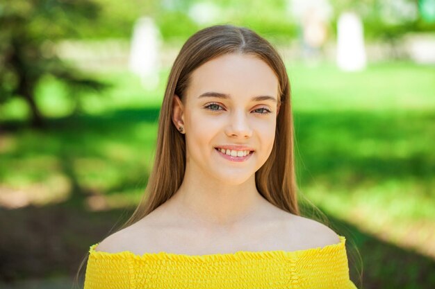 Closeup portrait of a teenage girl on the background of a city park