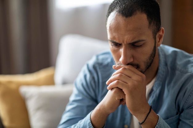 Closeup Portrait Of Thoughtful Young Black Man At Home Interior