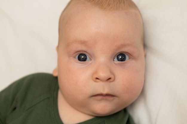 closeup portrait of a threemonthold baby with blue eyes dressed in green