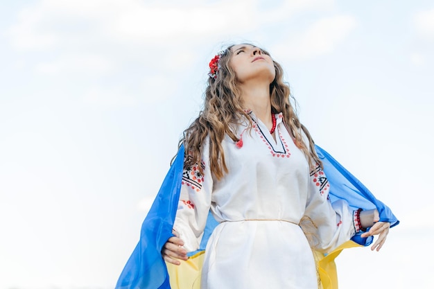Крупным планом портрет украинской девушки в традиционном костюме с украинским сине-желтым флагом