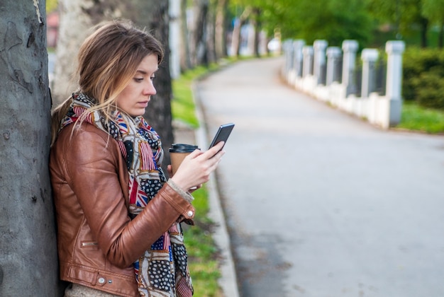 Closeup ritratto sconvolto scettici scettici donna seria infelice parlando texting sul telefono dispiaciuto con la conversazione isolato all'aperto parco sfondo. emozione negativa di emozione dell'uomo faccia espressione sensazione