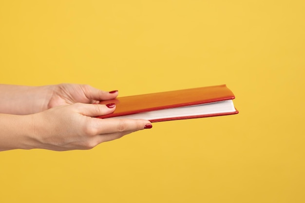 Closeup portrait of woman hand holding giving book with interesting plot studying with pleasure