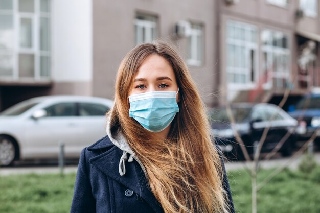 Closeup portrait of a woman in a medical mask on the street, epidemic of a coronavirus. woman violated the rules of self-isolation. SARS-CoV-2. protect yourself from COVID-19.