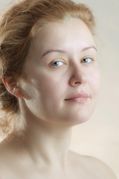 Closeup portrait of a young adult attractive woman with red hair without makeup. Art toning. Soft focus. Neutral background.