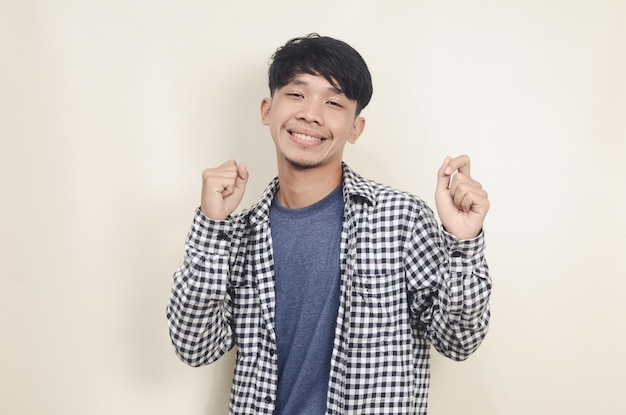 Closeup portrait of young Asian male model wearing plaid shirt with dancing motion on isolated background