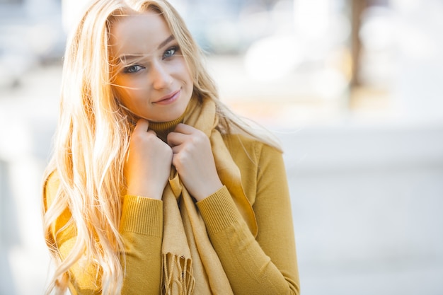 Closeup portrait of young attractive woman outdoors with copy space. Beautiful blond girl model. Cheerful ladyin spring, fall, autumn.