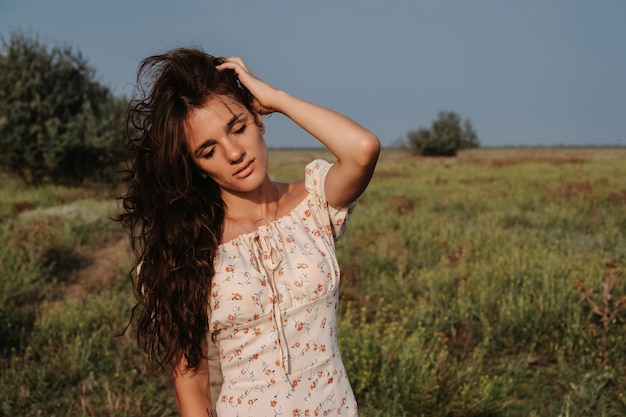 Closeup Portrait of a young Caucasian woman enjoying nature on picturesque steppe landscape Autumn or summer