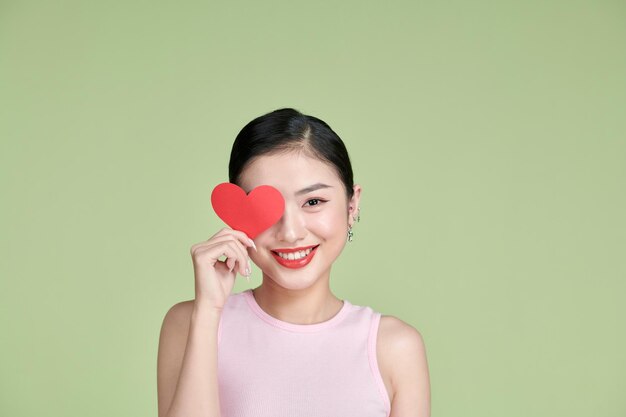 심장 모양을 들고 젊은 여성의 근접 촬영 초상화