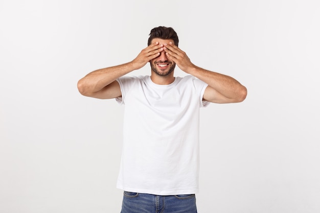 Closeup portrait of young guy, man, student, boy, worker, employee, closing eyes with hands, can't see, hiding, isolated on white.