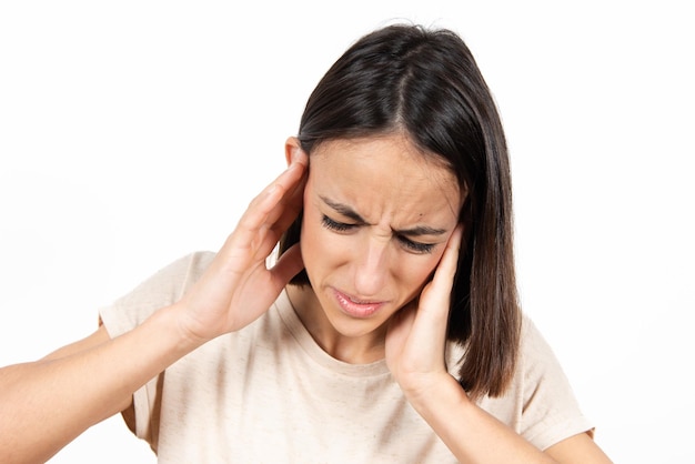 Closeup portrait of a young hispanic woman whith her hands on ears suffering earache or ear pain