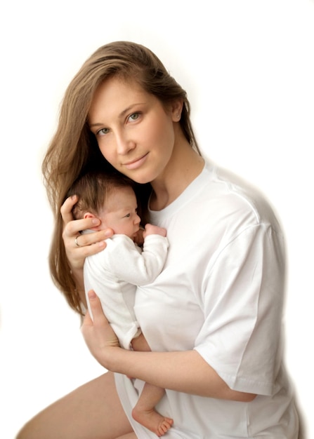 Ritratto del primo piano di una giovane madre e di una madre appena nata tiene tra le braccia abbraccia dolcemente baci una bella figlia appena nata il concetto di amore maternità felice foto su sfondo bianco