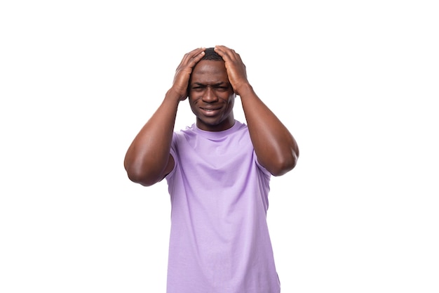 Photo closeup portrait of a young pensive african man in a lilac tshirt worried