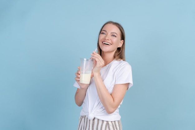 Closeup portrait young smiling woman holding drink with straw and looking