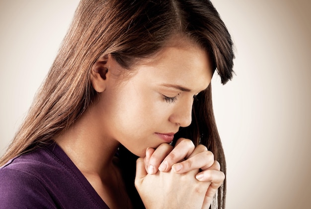 기도하는 젊은 여자의 근접 촬영 초상화