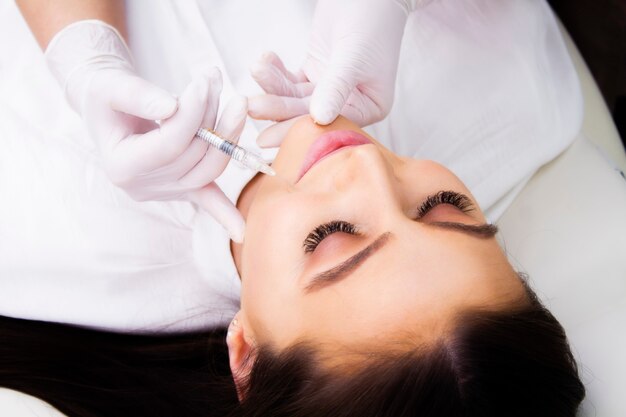 Closeup portrait of a young woman on top view wrinkle treatment procedure.