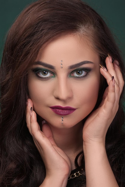 Closeup portret meisje met groene oogschaduw make-up gezichtsstenen kristallen