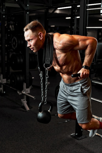 Closeup portret van een gespierde man training met barbell op sportschool. Brutale bodybuilder atletische man met sixpack, perfecte buikspieren, schouders, biceps, triceps en borst.