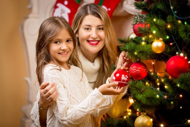 Closeup portret van moeder met dochter kerstboom versieren