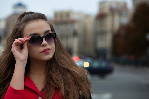 Closeup portret van prachtige brunette model met lang haar poseren in de stad van de avond. Ruimte voor tekst