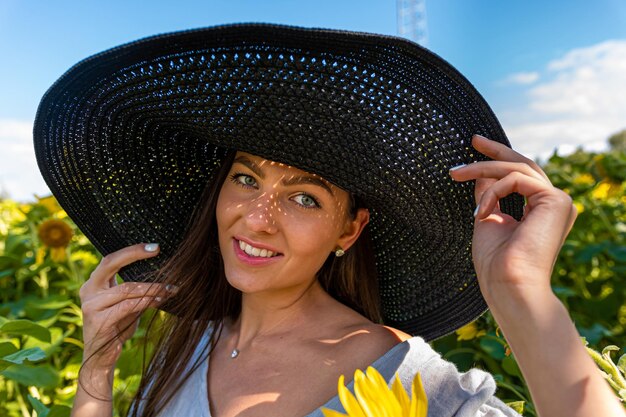 Closeup portret van vrouw in elegante hoed genieten van zomerzon patroon van schaduwen die op haar gezicht vallen