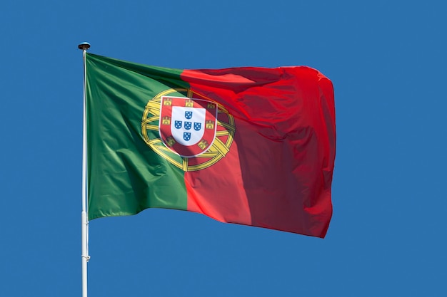 Closeup on the Portuguese Flag waving atop of a pole