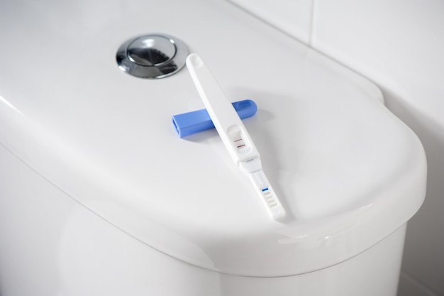 긍정적인 임신(낮은 조명 및 얕은 피사계 심도)이 있는 근접 촬영 임신 테스트