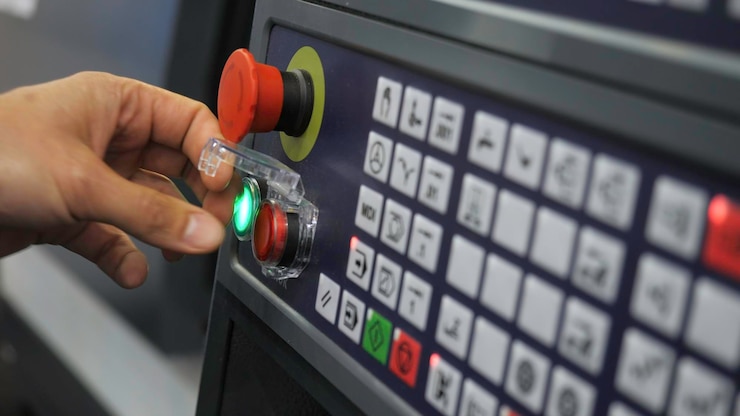 Photo closeup pressing buttons of machine control panel media starting production machine using control