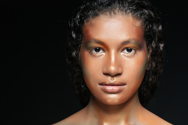 Closeup of pretty american young woman with fashion makeup over black