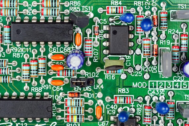 Closeup of a printed circuit board with components such as Resistors and integrated circuits