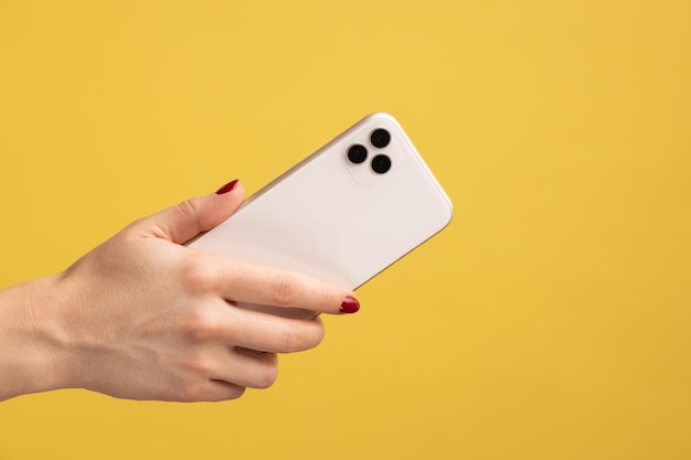 Closeup profile portrait of woman hand holding mobile phone showing back side of cell phone