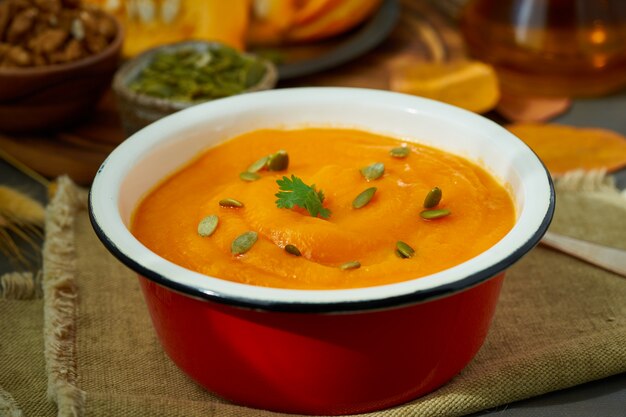 Closeup of pumpkin soup, autumn dish, healthy food, seeds and walnuts 