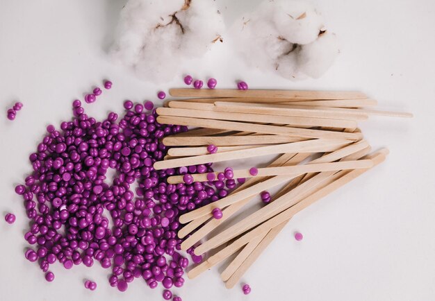 Closeup of purple wax granules scattered from a jar Beauty procedure to remove unwanted hair from the body