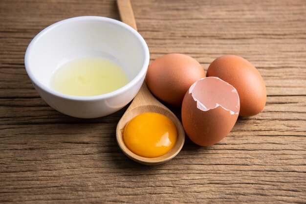 Closeup of raw chicken eggs in egg box on brown wood