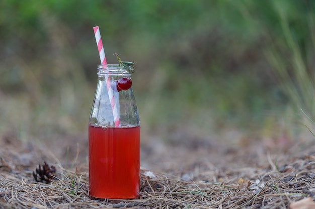 Closeup of a red detox drink with a red drinking straw,