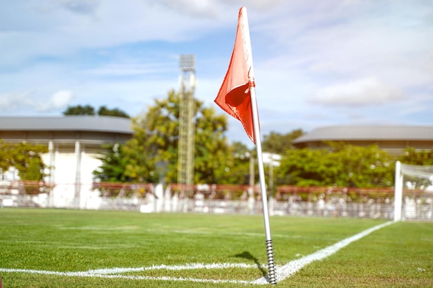 明るい青空とサッカー グラウンド コーナーで赤い旗をクローズ アップ