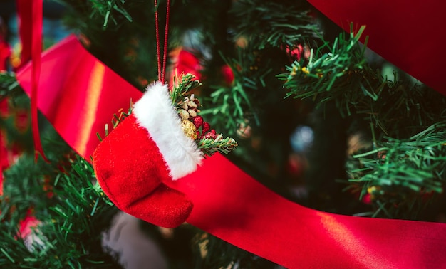 Closeup of Red Santa Claus socks and red ribbon on Christmas tree Christmas background