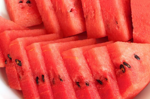 Closeup of red watermelon slices on white plate.