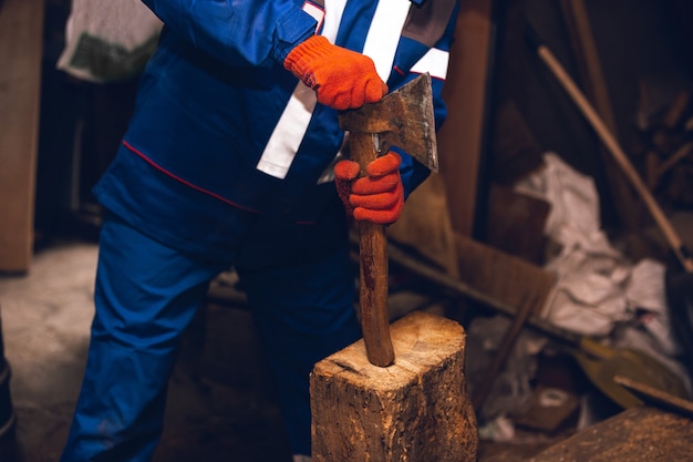 Closeup of repairman in uniform, professional builder working using construction equipment. Process of building, apartment renovation, repairing, building. Sawing, connecting, cutting, preparing.