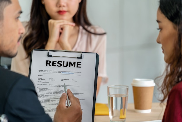 Photo closeup resume in two manager hand holding when discuss about her resume with serious motion