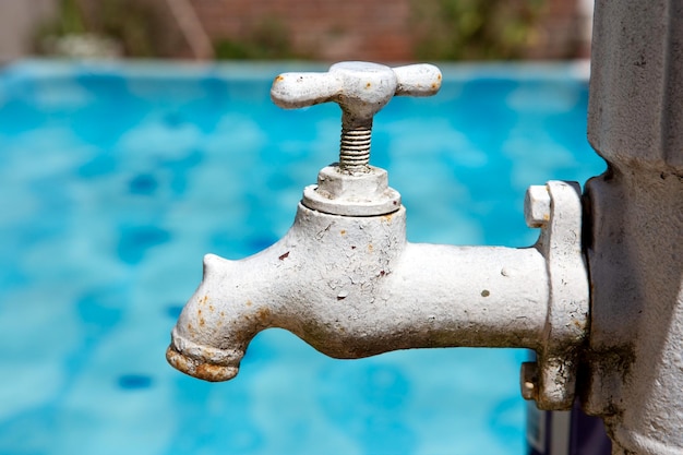 Closeup of retro faucet with rust and cracked paint