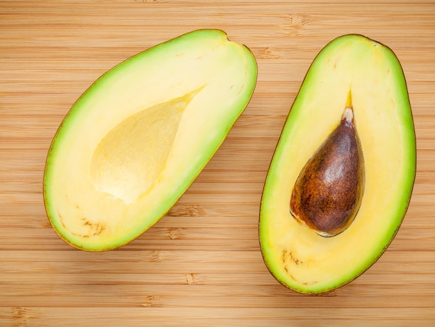 Closeup ripe avocado on wooden background. 